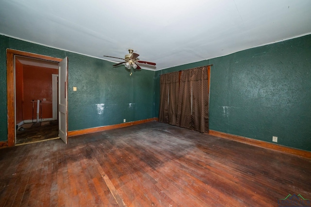 empty room featuring ceiling fan and dark wood-type flooring