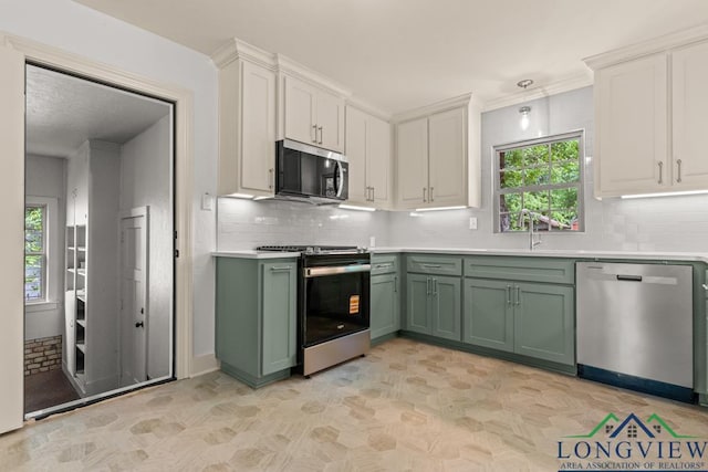 kitchen with light countertops, a sink, appliances with stainless steel finishes, and green cabinets