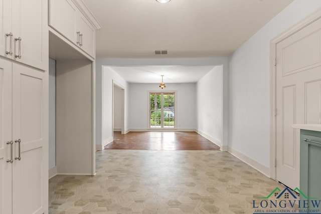interior space featuring parquet flooring, baseboards, and visible vents