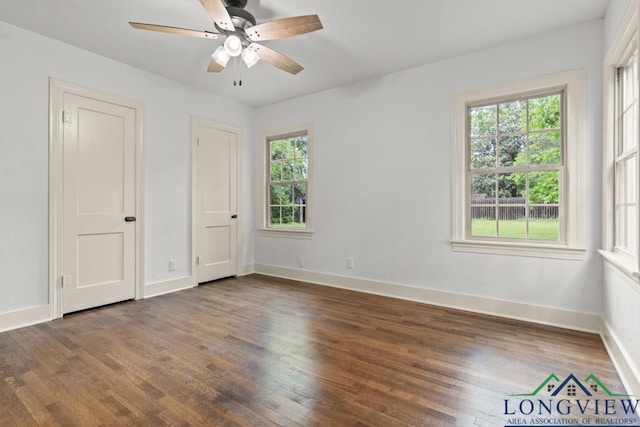 unfurnished bedroom with baseboards, a ceiling fan, wood finished floors, and multiple windows