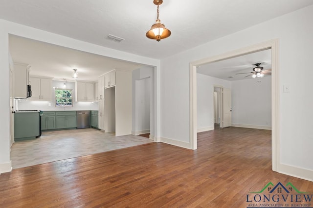 unfurnished living room with baseboards, ceiling fan, and light wood finished floors