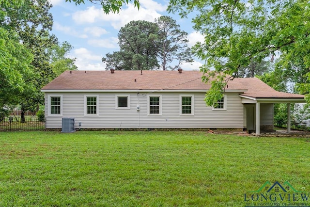 back of property with roof with shingles, central air condition unit, a yard, and fence