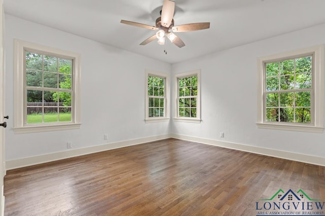 empty room with plenty of natural light and wood finished floors