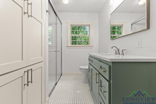 bathroom featuring a healthy amount of sunlight, vanity, a shower stall, and toilet