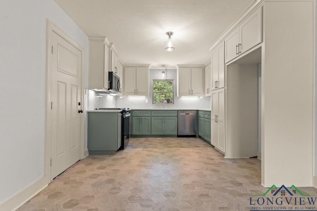 kitchen featuring appliances with stainless steel finishes, light countertops, baseboards, decorative backsplash, and green cabinets