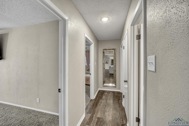 hall with dark hardwood / wood-style floors and a textured ceiling