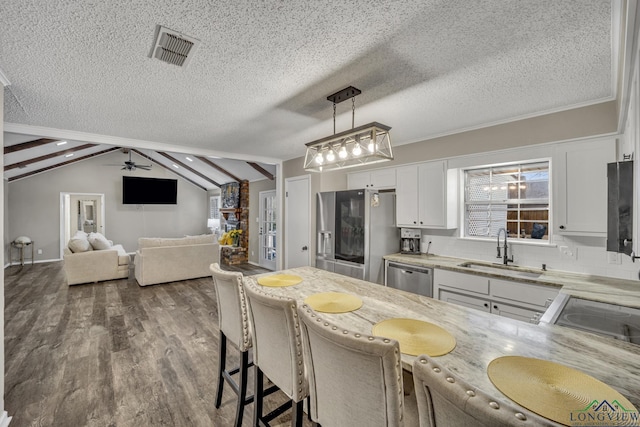 kitchen featuring sink, white cabinetry, hanging light fixtures, a kitchen breakfast bar, and stainless steel appliances