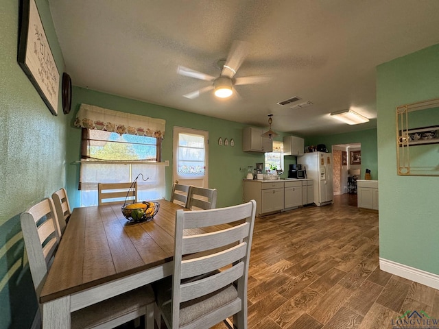 dining area with ceiling fan, hardwood / wood-style floors, and a textured ceiling