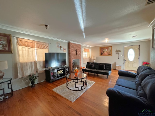 living room with hardwood / wood-style flooring and crown molding