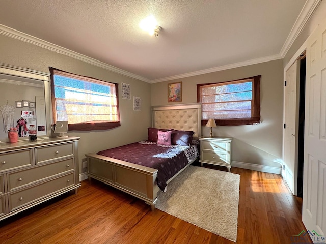 bedroom with crown molding, wood-type flooring, and a textured ceiling