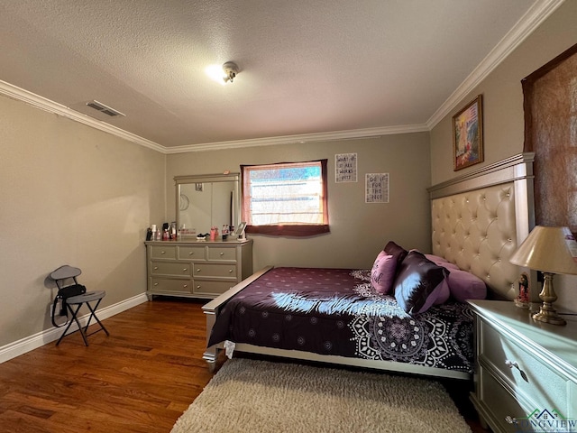 bedroom featuring dark wood-type flooring, ornamental molding, and a textured ceiling