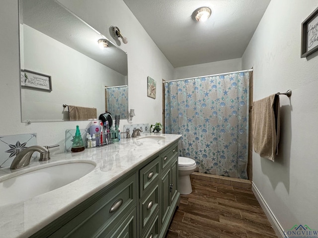 bathroom with hardwood / wood-style flooring, vanity, a textured ceiling, and toilet