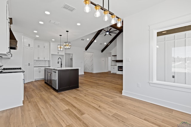kitchen featuring white cabinetry, open floor plan, visible vents, and tasteful backsplash