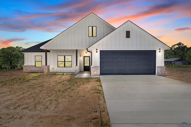 modern inspired farmhouse featuring board and batten siding, an attached garage, and concrete driveway