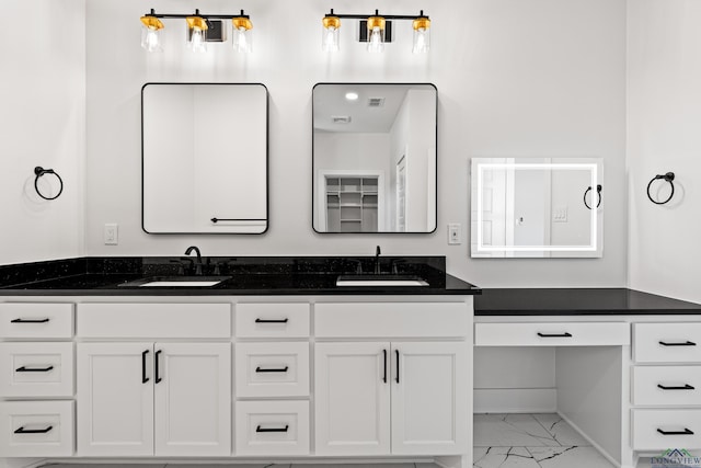 bathroom with double vanity, visible vents, a sink, and marble finish floor
