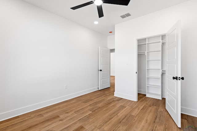 unfurnished bedroom featuring a closet, baseboards, visible vents, and light wood-style floors