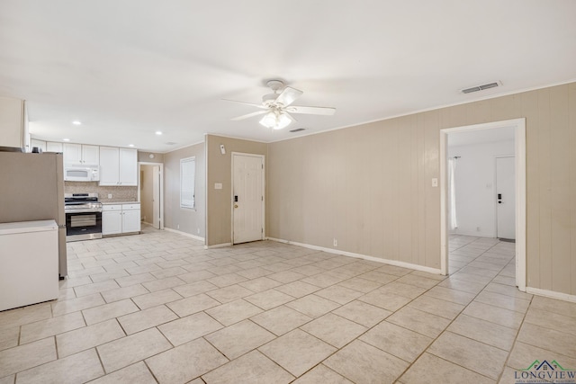 kitchen with refrigerator, ceiling fan, stainless steel range, light tile patterned flooring, and white cabinetry