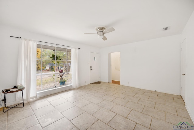 empty room featuring ceiling fan and light tile patterned floors