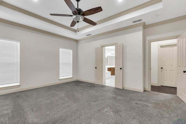 unfurnished bedroom with carpet, visible vents, a raised ceiling, and ornamental molding