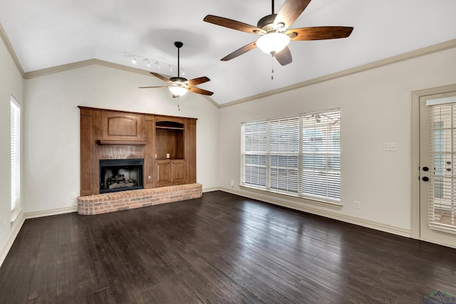 unfurnished living room with ornamental molding, lofted ceiling, a brick fireplace, and dark wood finished floors