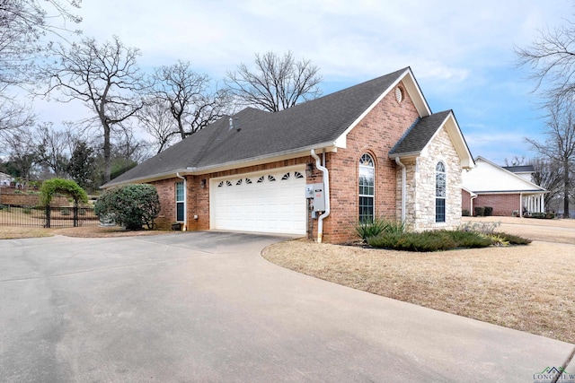 view of property exterior with driveway, brick siding, stone siding, and fence