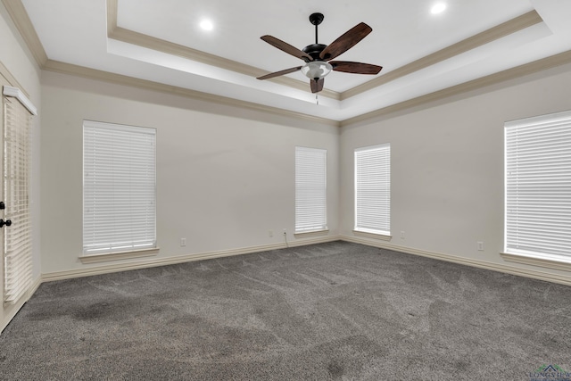 spare room with a ceiling fan, a tray ceiling, crown molding, and carpet