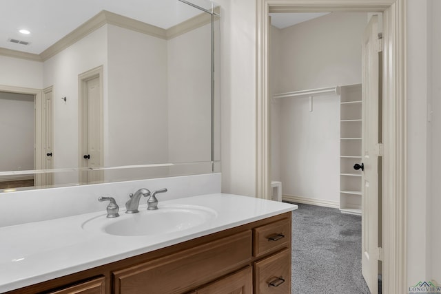 bathroom featuring visible vents, ornamental molding, a spacious closet, vanity, and recessed lighting