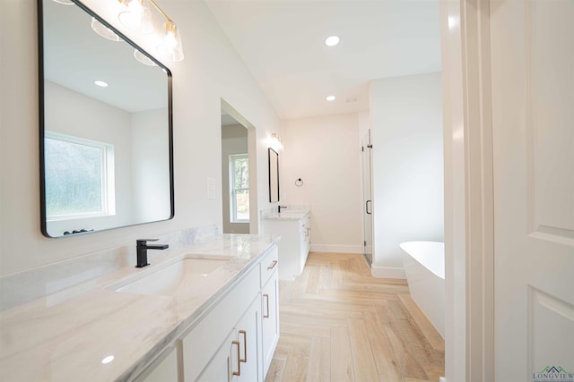 264 Clara Ln, Kilgore, TX 75662 - bathroom featuring a sink, a freestanding bath, two vanities, and a wealth of natural light