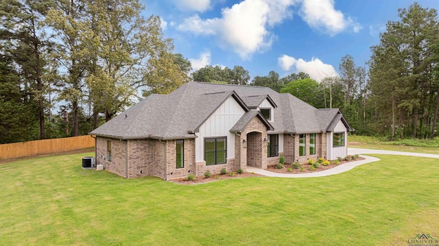264 Clara Ln, Kilgore, TX 75662 - view of front of property featuring fence, brick siding, a front lawn, board and batten siding, and central AC unit