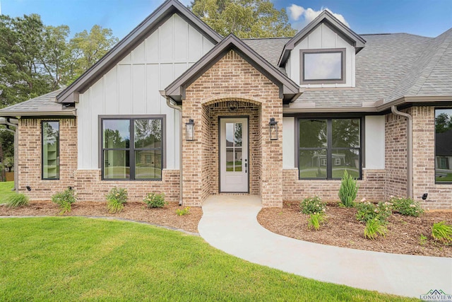 264 Clara Ln, Kilgore, TX 75662 - view of front of house featuring board and batten siding, brick siding, roof with shingles, and a front yard