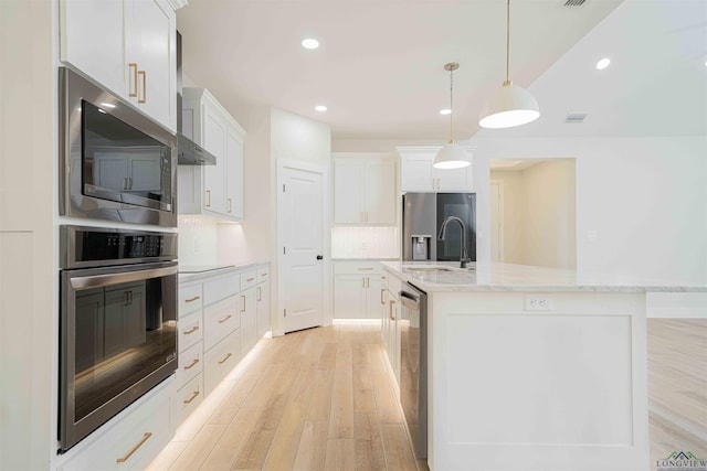 264 Clara Ln, Kilgore, TX 75662 - kitchen featuring light wood finished floors, hanging light fixtures, stainless steel appliances, white cabinets, and a center island with sink