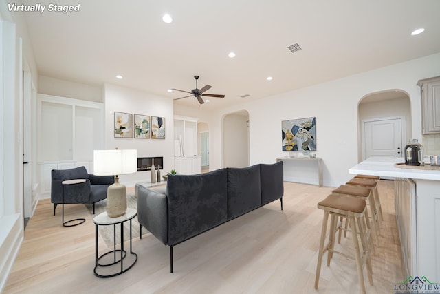 living room with light hardwood / wood-style floors and ceiling fan