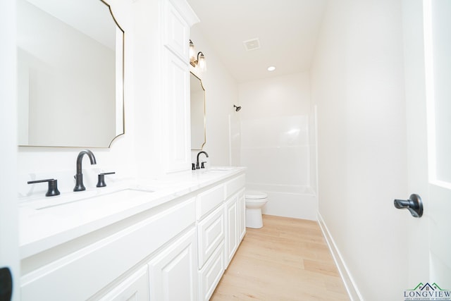 bathroom with hardwood / wood-style flooring, vanity, and toilet