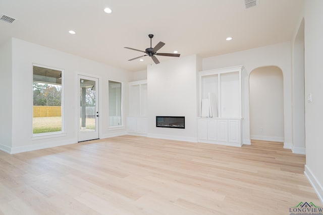 unfurnished living room featuring ceiling fan and light wood-type flooring