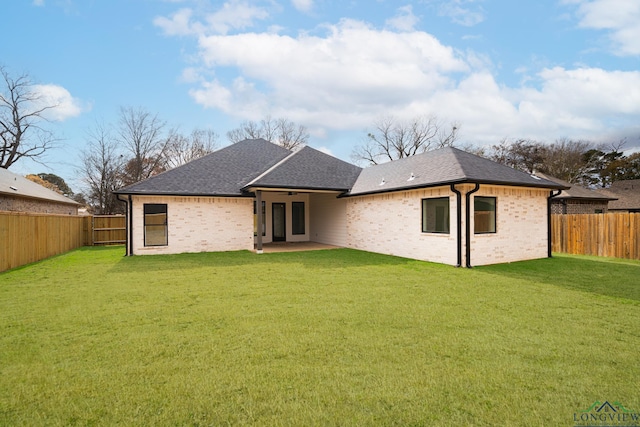 rear view of house with a yard and a patio area