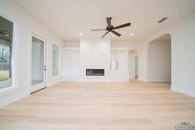 unfurnished living room with ceiling fan and light wood-type flooring