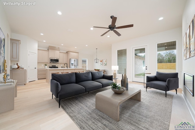 living room featuring sink and light hardwood / wood-style floors