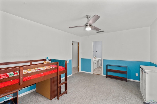 bedroom featuring ensuite bathroom, ceiling fan, and light carpet