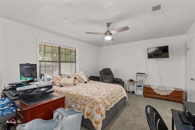 carpeted bedroom featuring a textured ceiling and ceiling fan