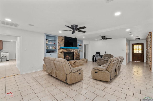 living room with built in shelves, light tile patterned flooring, a fireplace, and ceiling fan