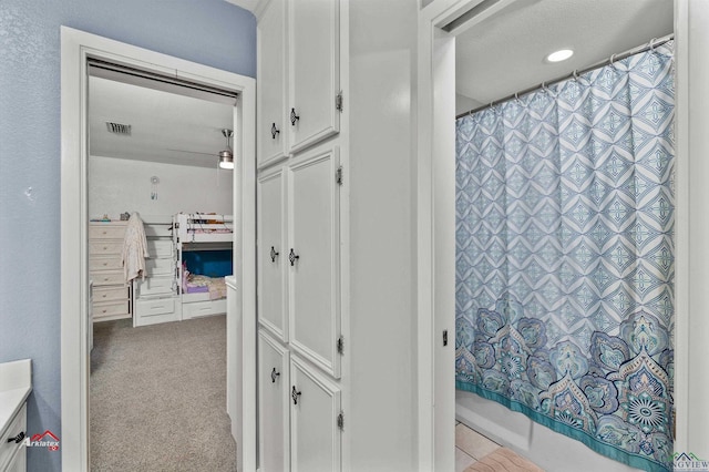 bathroom with vanity, a textured ceiling, and shower / tub combo with curtain