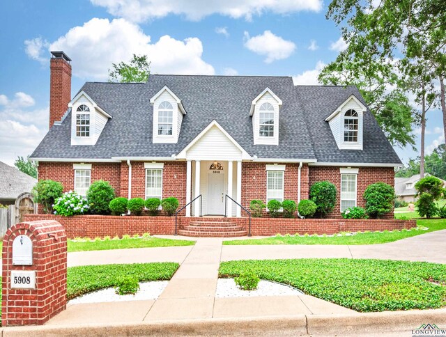 5908 Regents Row, Tyler, TX 75703 - new england style home featuring brick siding, a shingled roof, a chimney, and a front yard