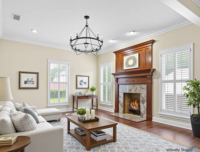 5908 Regents Row, Tyler, TX 75703 - living area with healthy amount of natural light, a chandelier, wood finished floors, ornamental molding, and a high end fireplace