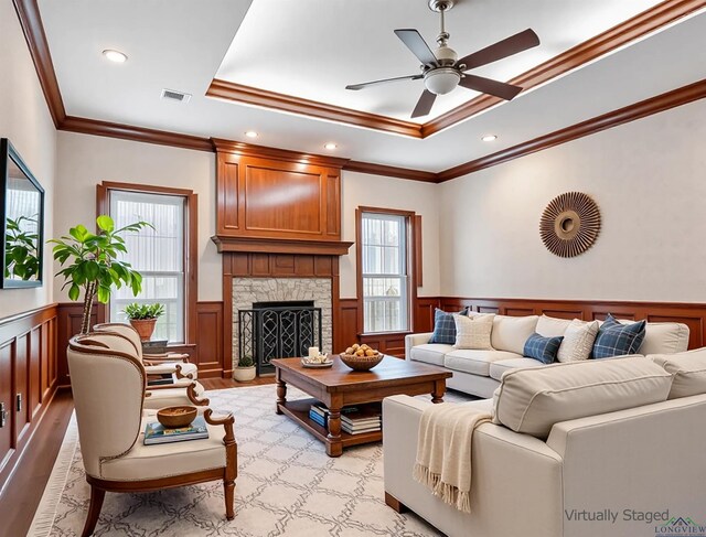 5908 Regents Row, Tyler, TX 75703 - living room with healthy amount of natural light, a tray ceiling, a wainscoted wall, ceiling fan, and crown molding