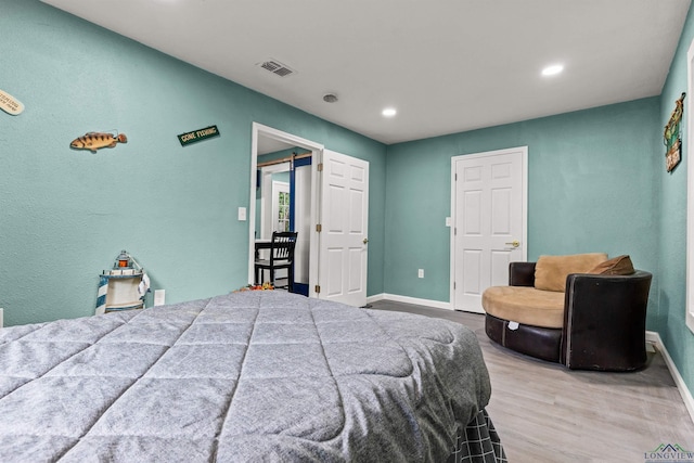 bedroom with recessed lighting, visible vents, wood finished floors, and baseboards