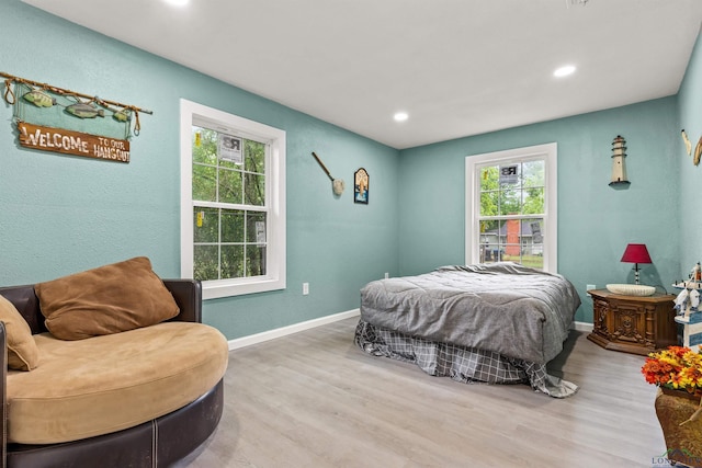 bedroom featuring recessed lighting, wood finished floors, and multiple windows