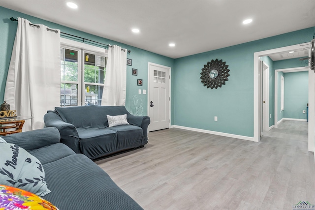 living room with light wood-type flooring, recessed lighting, and baseboards