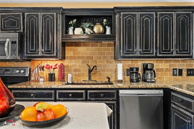 kitchen with sink, decorative backsplash, stainless steel appliances, and light stone countertops