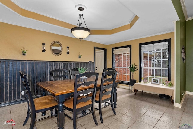 dining room with crown molding, tile patterned floors, and a raised ceiling