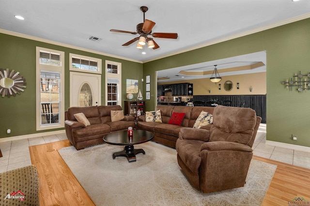 living room featuring ceiling fan, ornamental molding, and light hardwood / wood-style floors